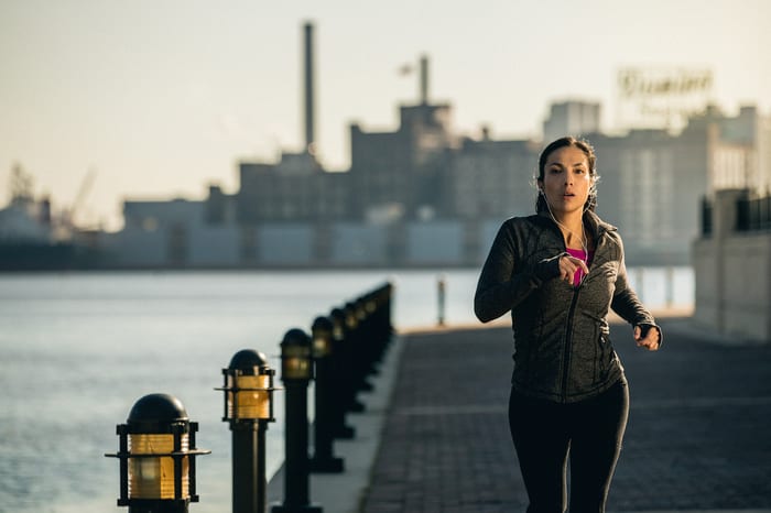 woman jogging in city after receiving fitness tip from brick bodies gyms blog