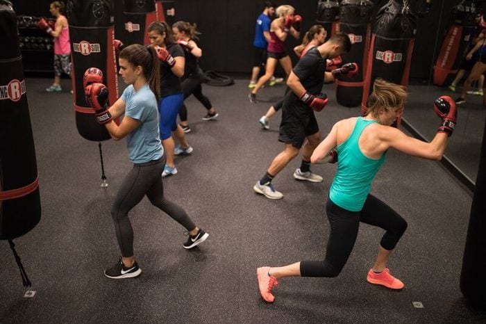 reisterstown gym members in group classes wearing gloves and hitting punching bags