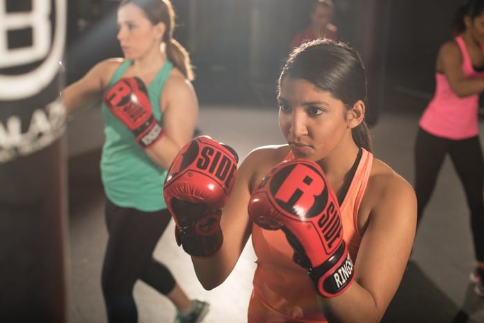 gym members at brick bodies padonia in les mills classes working out with boxing gloves