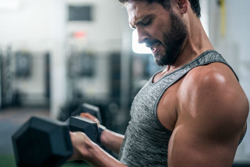 male fitness member using weights and dumbells to improve bicep strength