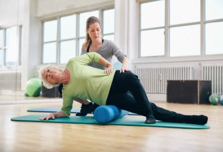 senior receiving instruction from fitness trainer during silver sneakers class at brick bodies reisterstown md