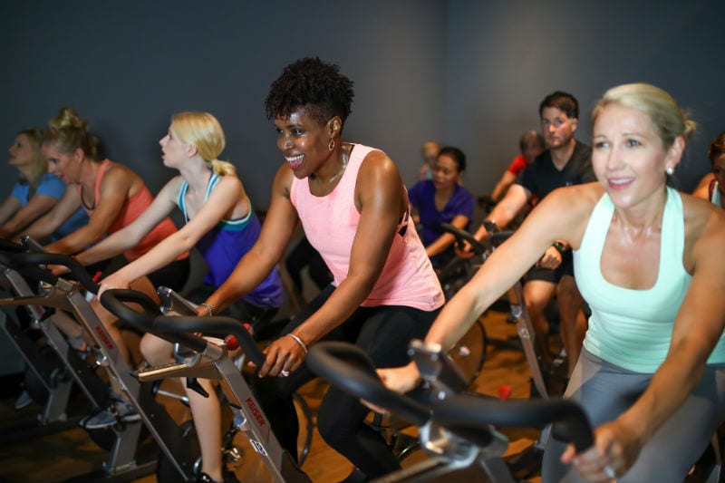 gym members on spin bicycles riding to the rhythm of the music at reisterstown in cycling classes