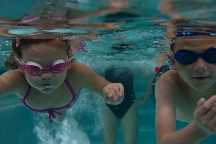 children swimming under water during swim lessons in padonia gym pool