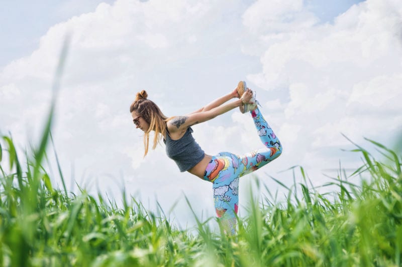 woman in field in yoga pose