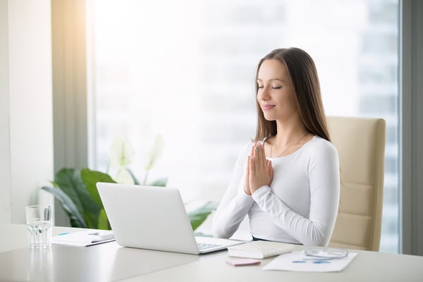 woman at desk watching virtual yoga classes from brick bodies padonia