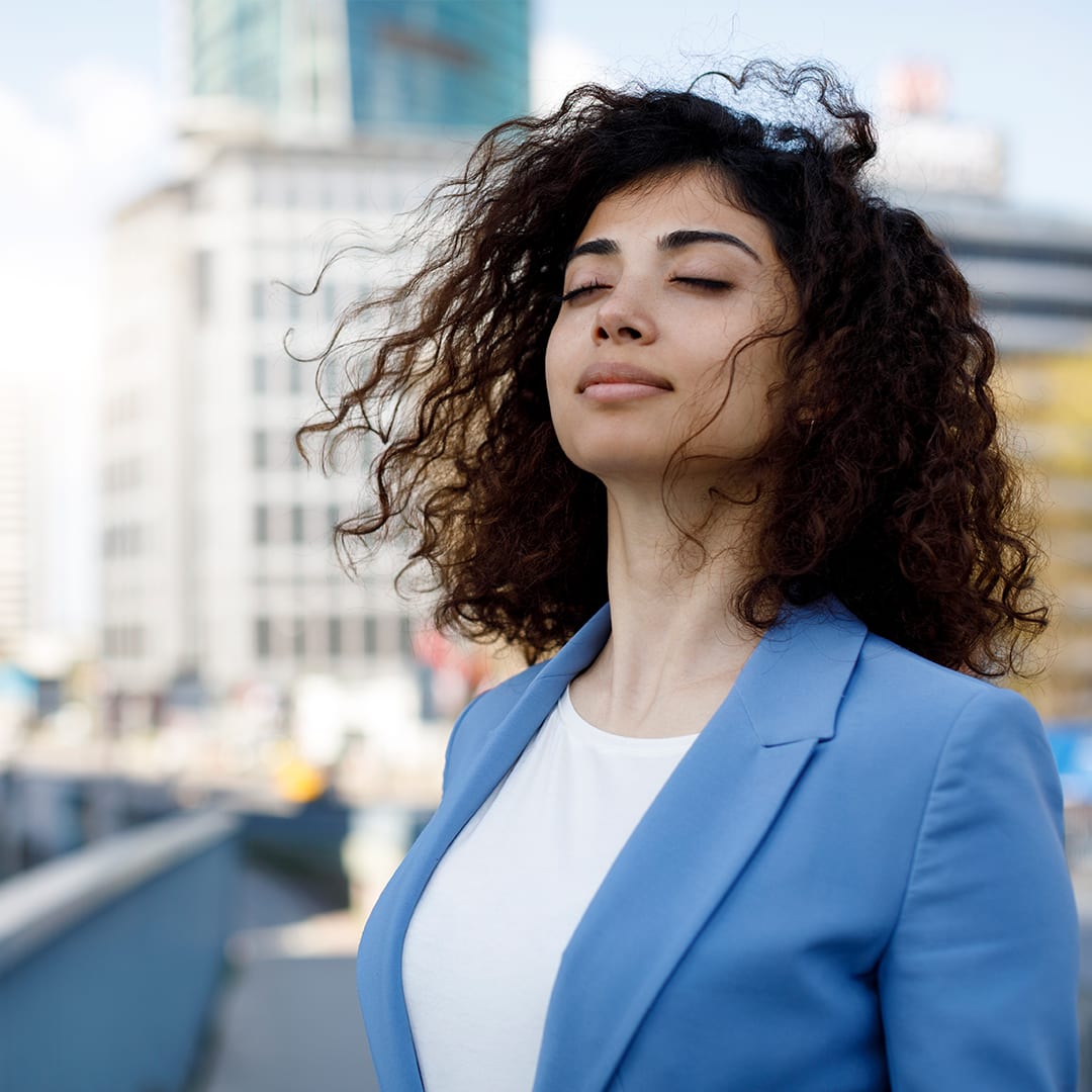 Businesswoman relaxing outdoor with deep breathing techniques