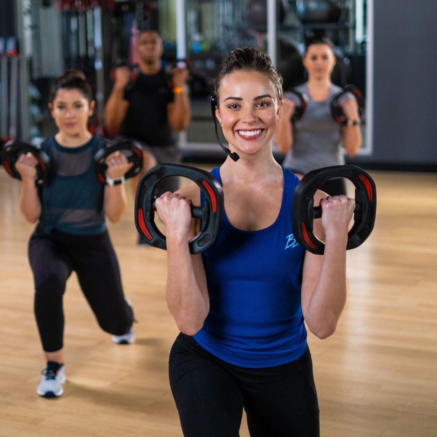 Woman lifting weights in a group fitness class